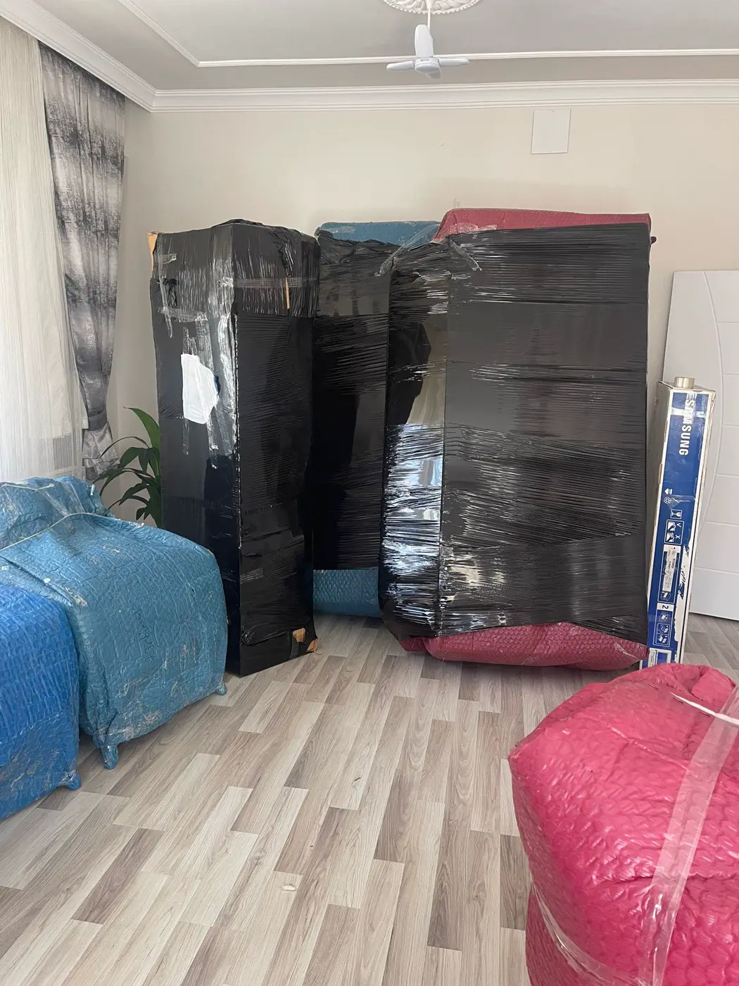 Koşuyolu nakliyat: siyah streç ve renkli koruyucularla paketlenmiş dolaplar