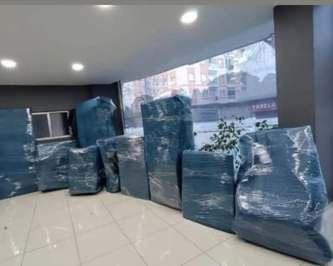 Koşuyolu nakliyat: boş salonda paketlenmiş mobilyalar