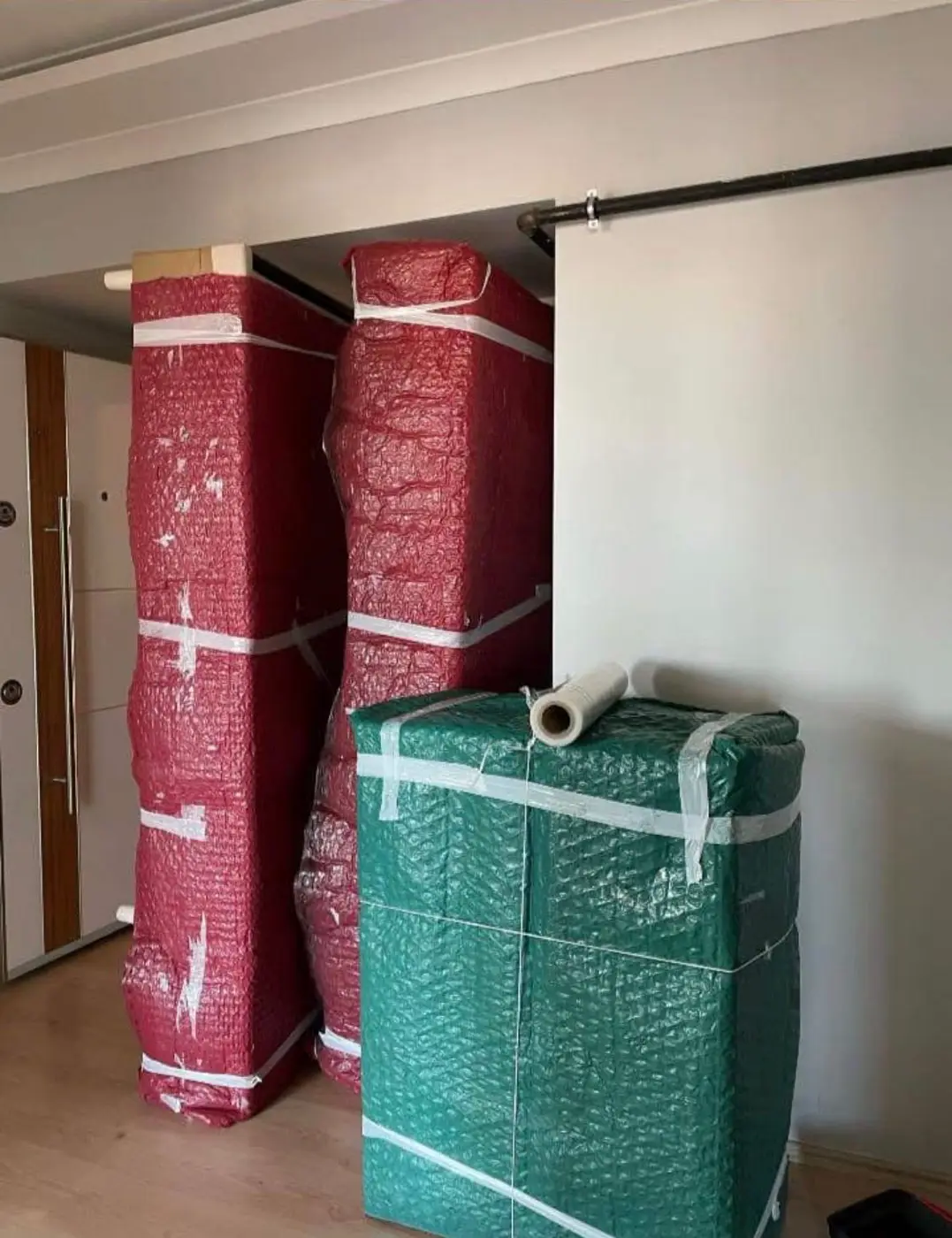Koşuyolu nakliyat: kırmızı ve yeşil koruyucularla paketlenmiş dolaplar