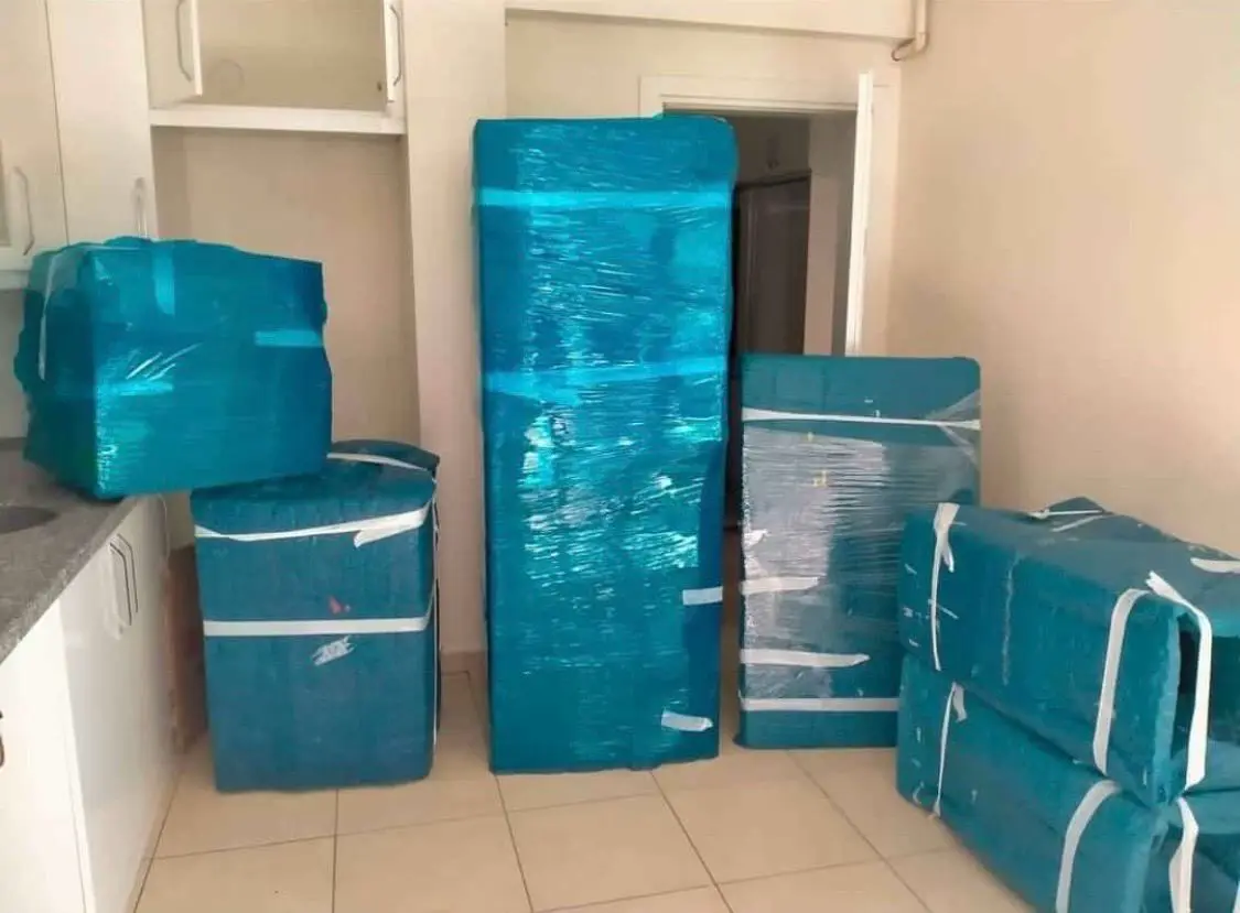 Koşuyolu nakliyat: turkuaz balonlu naylonla paketlenmiş eşyalar